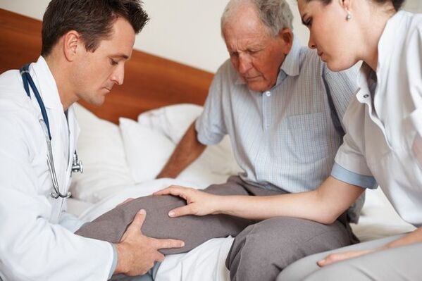 Medico che esamina il ginocchio del paziente